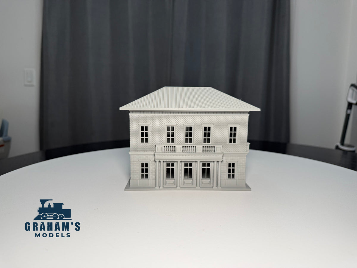 HO scale small train station by Graham’s Models, built and assembled, featuring detailed platform and station building with signage.