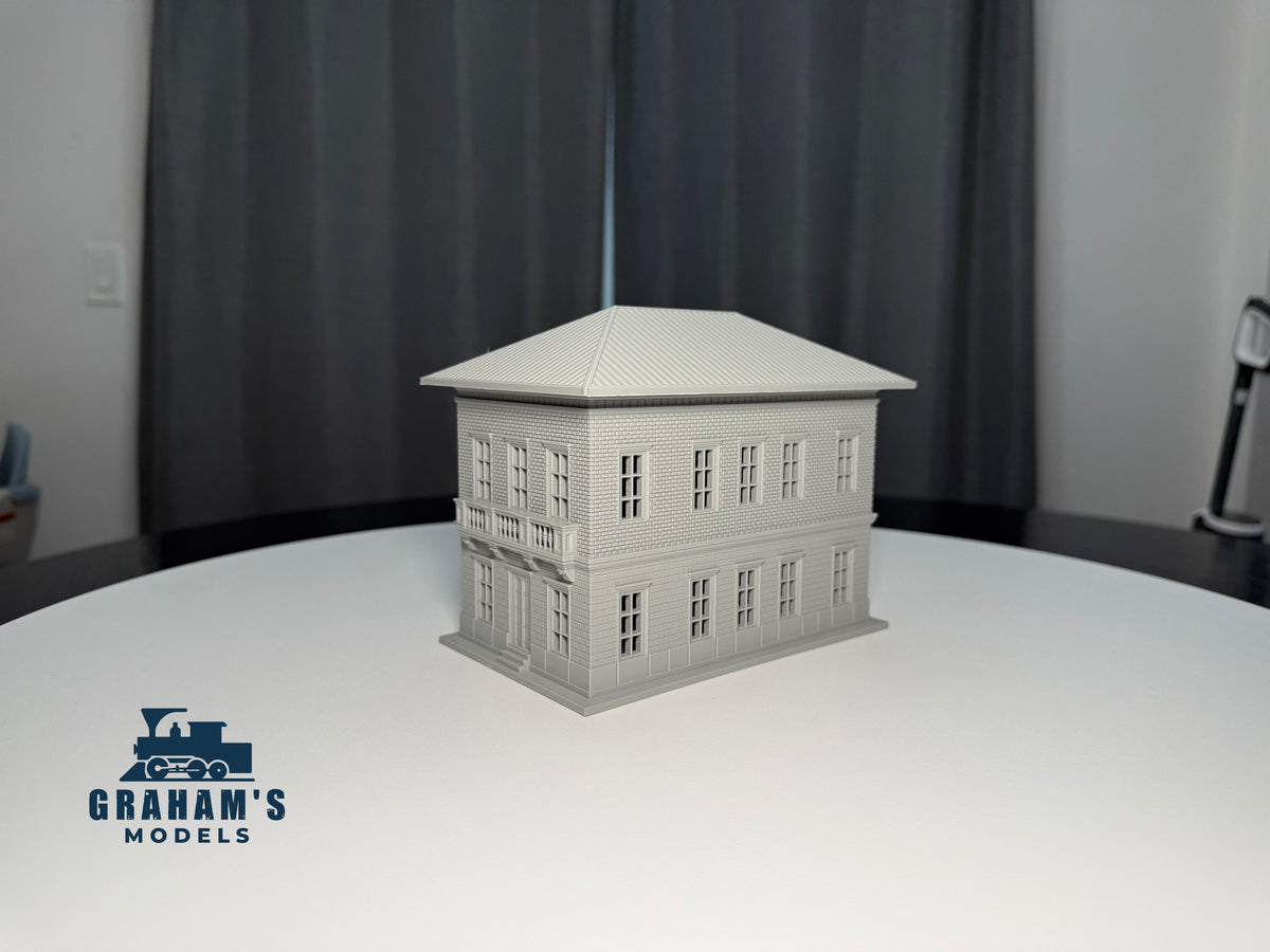 Small HO scale train station built and assembled by Graham’s Models, featuring detailed platform and station building for model railroads.