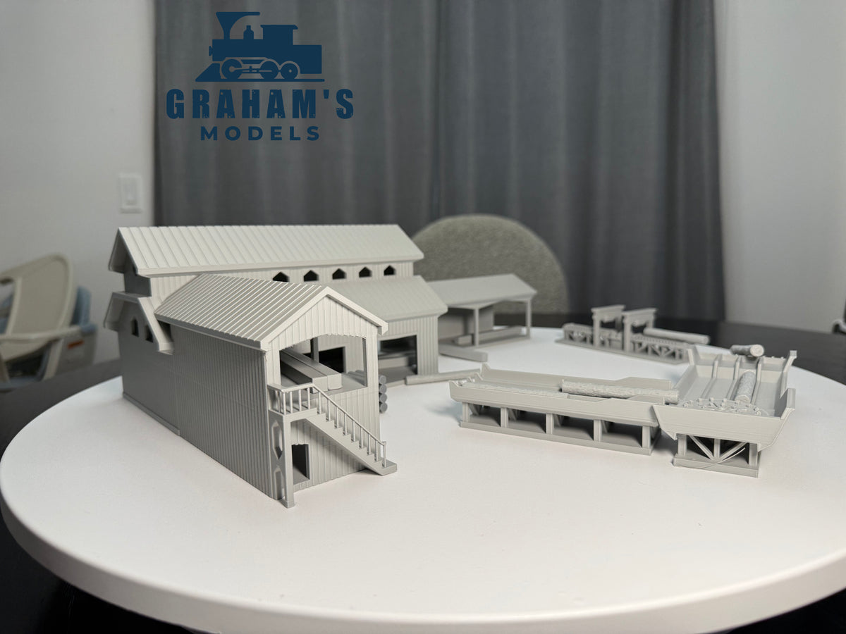 Preassembled HO scale sawmill lumber yard model by Graham’s Models, featuring detailed wooden structures and equipment.